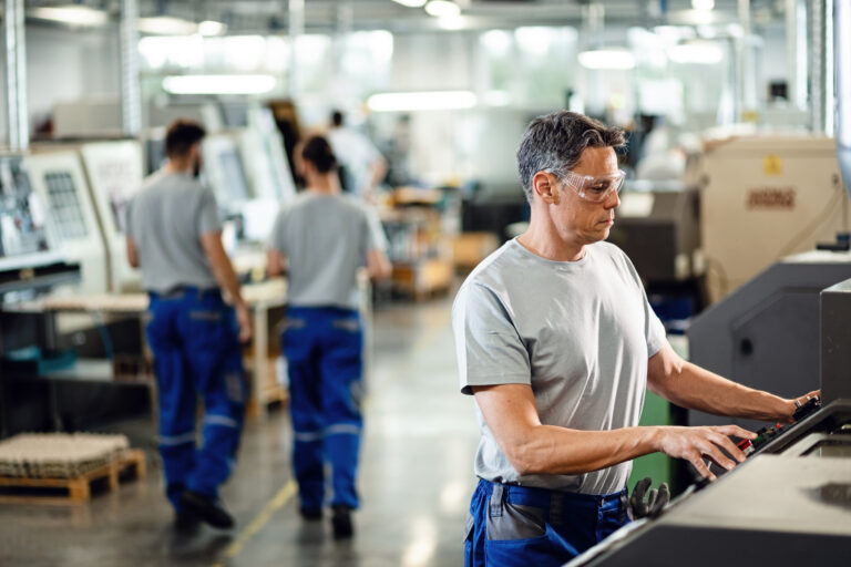 Industrial facility employee working at CNC machine